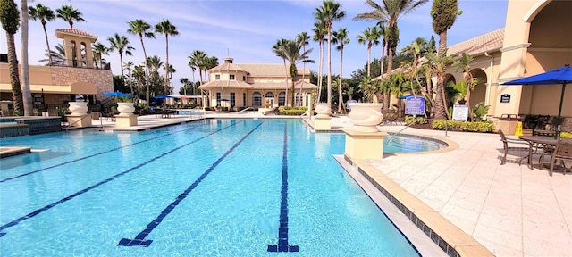 view of swimming pool with a jacuzzi and a patio