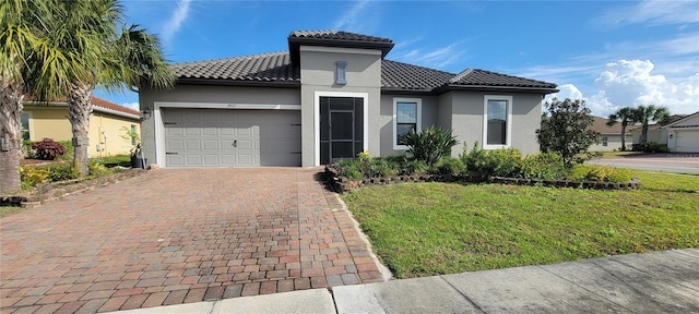 mediterranean / spanish house featuring a garage and a front lawn