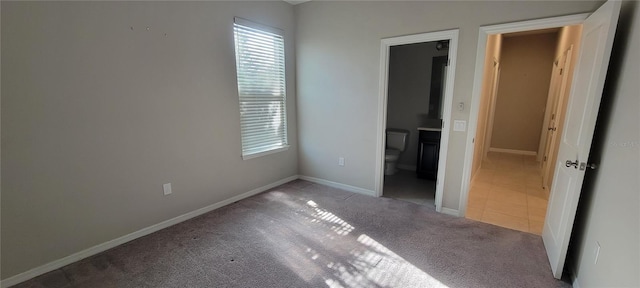 unfurnished bedroom featuring carpet flooring and connected bathroom