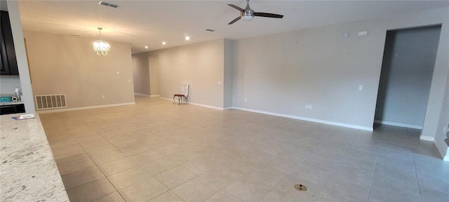 unfurnished living room with ceiling fan with notable chandelier and light tile patterned floors