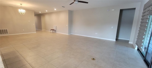 spare room featuring light tile patterned flooring and ceiling fan with notable chandelier