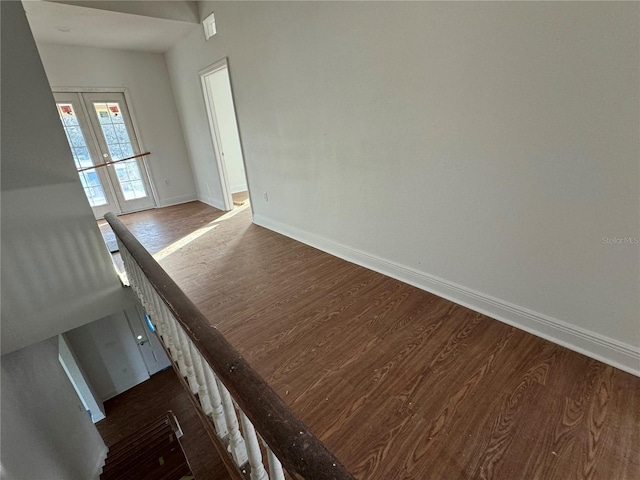 empty room with dark wood-type flooring and french doors