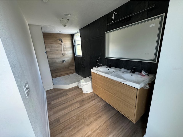 bathroom featuring hardwood / wood-style flooring, vanity, and walk in shower