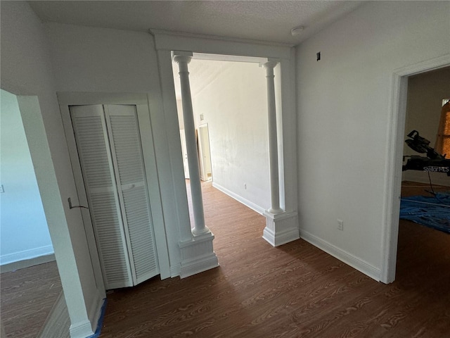 corridor with dark hardwood / wood-style floors and a textured ceiling