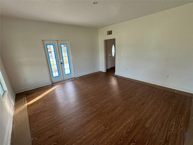 unfurnished room featuring dark hardwood / wood-style flooring and french doors