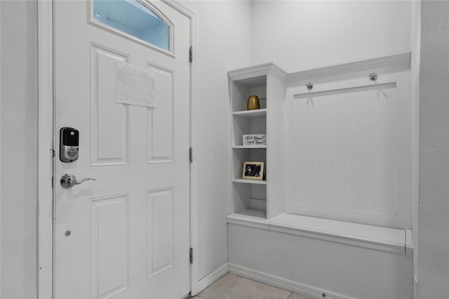 mudroom with built in features and light tile patterned flooring