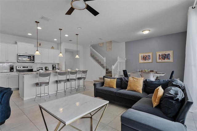 tiled living room with ceiling fan