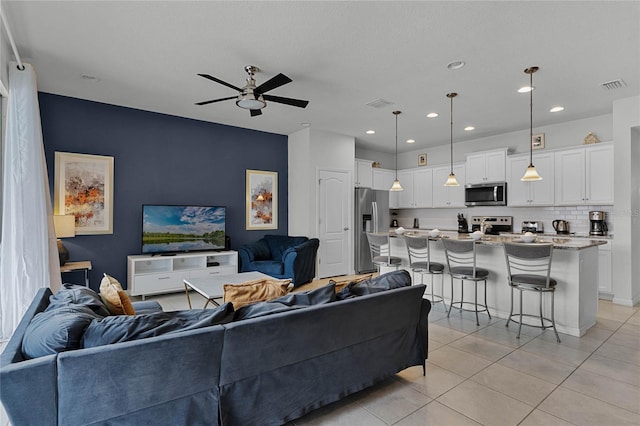 living room featuring ceiling fan and light tile patterned flooring