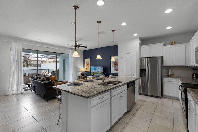 kitchen featuring ceiling fan, sink, stainless steel appliances, a kitchen island with sink, and white cabinets