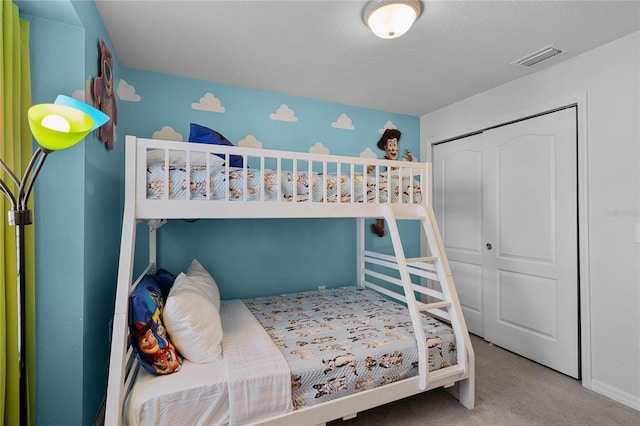 bedroom featuring a textured ceiling, carpet floors, and a closet