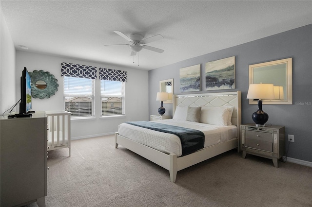 carpeted bedroom featuring a textured ceiling and ceiling fan