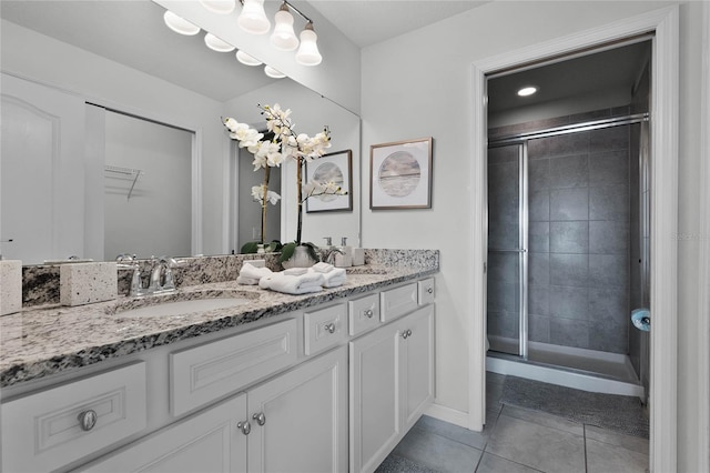 bathroom featuring vanity, a shower with shower door, and tile patterned flooring