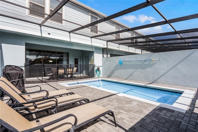 view of swimming pool featuring a patio area and a lanai