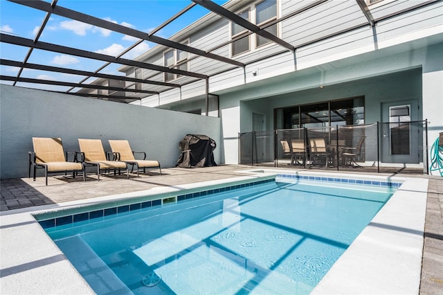 view of swimming pool featuring a patio and glass enclosure