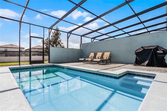 view of swimming pool featuring a patio and glass enclosure