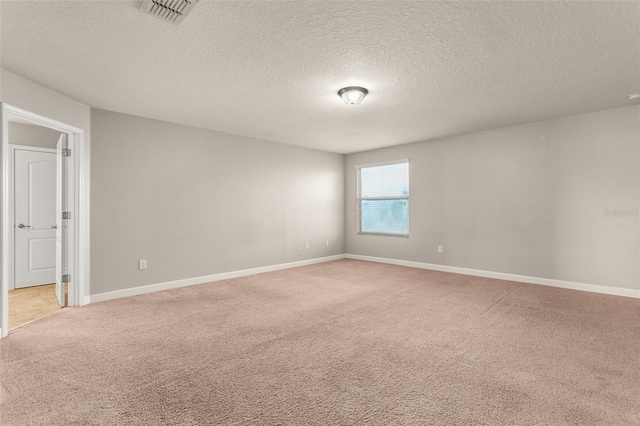 carpeted empty room with a textured ceiling