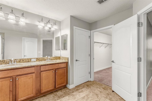 bathroom featuring tile patterned flooring, vanity, and a textured ceiling