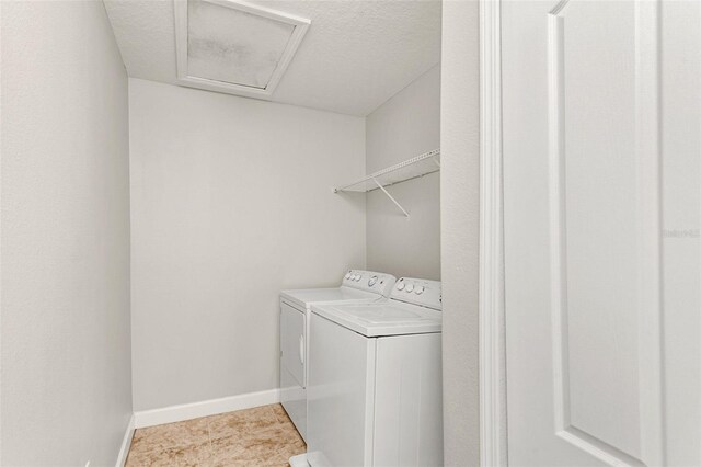 clothes washing area with light tile patterned floors, a textured ceiling, and separate washer and dryer