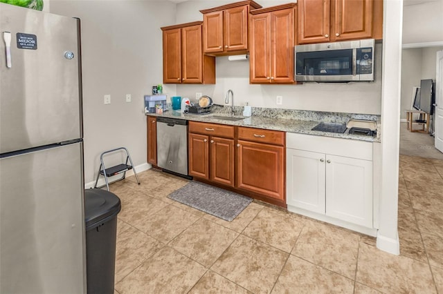 kitchen featuring light tile patterned flooring, sink, light stone countertops, and stainless steel appliances