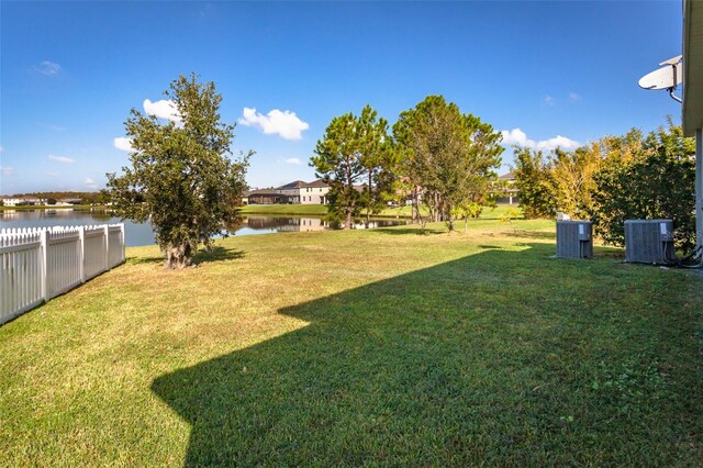 view of yard with a water view and central AC unit