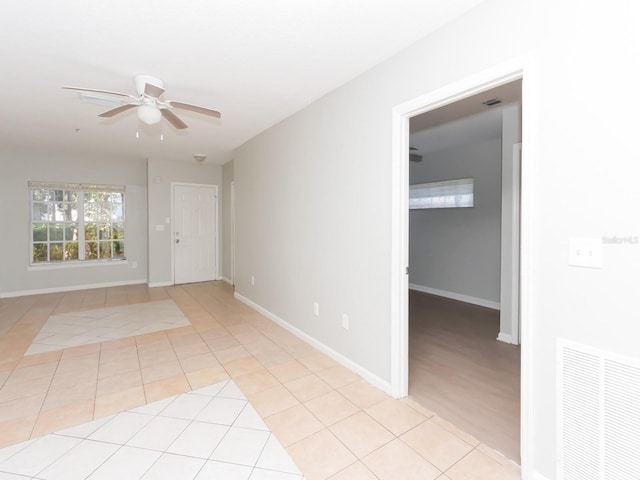 tiled spare room featuring ceiling fan