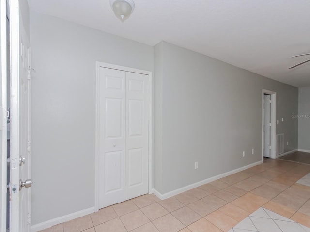 unfurnished bedroom with light tile patterned floors and a closet