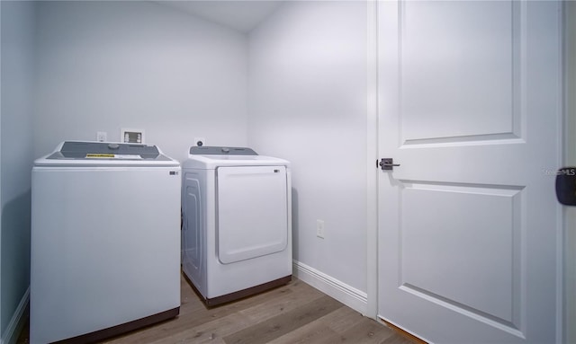 17207 Waldrun Ave, Port Charlotte, FL 33948 - laundry room with separate washer and dryer, light wood-type flooring, and baseboards