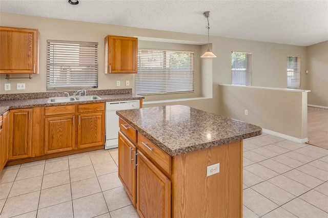 kitchen with a textured ceiling, sink, decorative light fixtures, dishwasher, and a center island