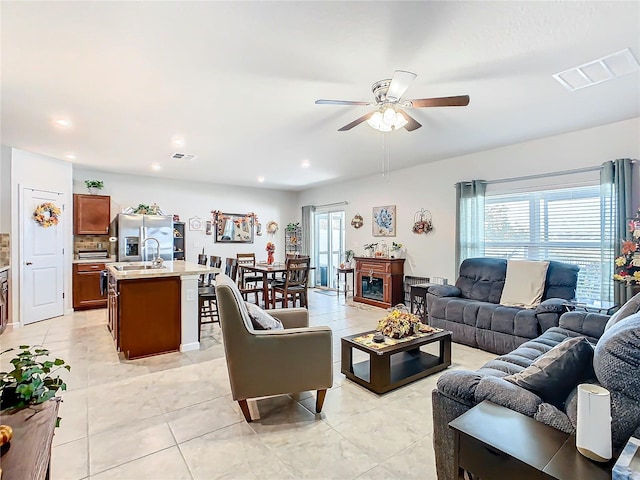 living room with ceiling fan, light tile patterned flooring, and sink