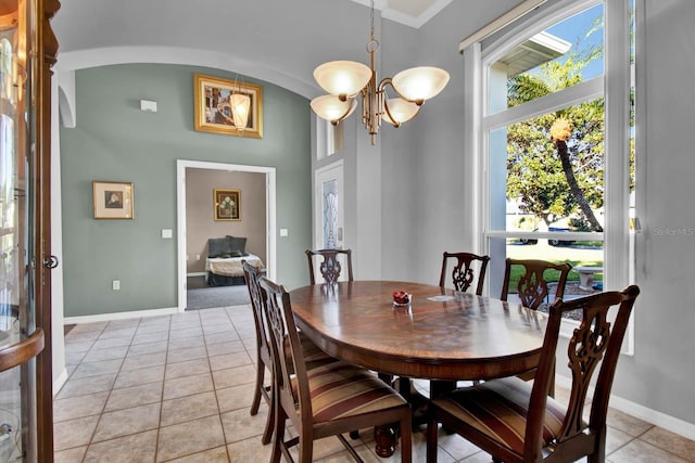 tiled dining space featuring lofted ceiling and an inviting chandelier