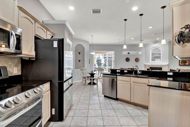 kitchen with light brown cabinetry, sink, decorative light fixtures, appliances with stainless steel finishes, and backsplash