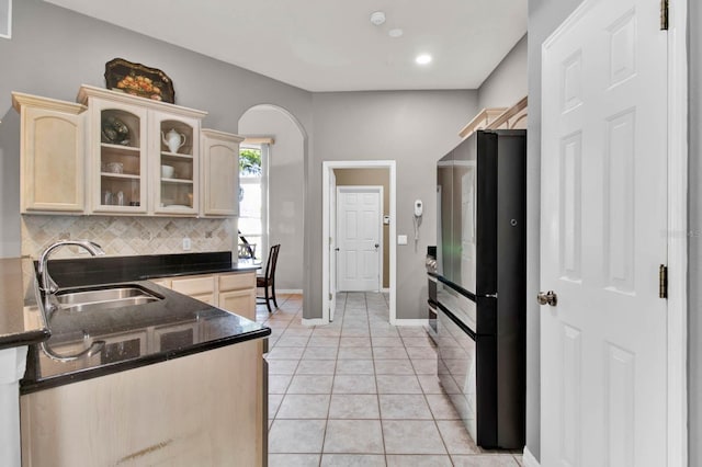 kitchen with sink, backsplash, fridge, light tile patterned flooring, and light brown cabinets