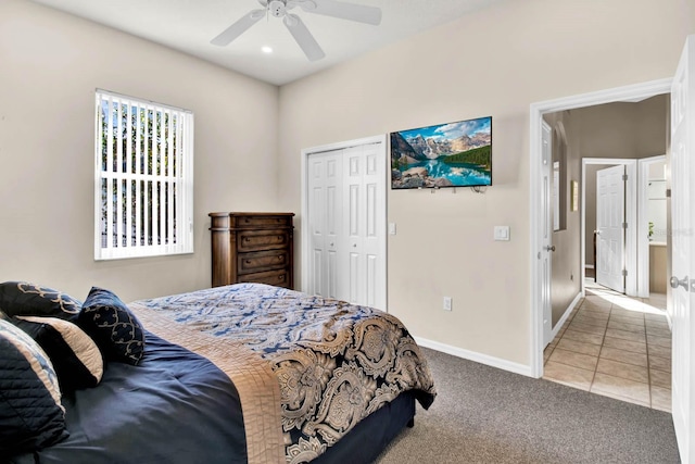 bedroom featuring light carpet, ceiling fan, and a closet