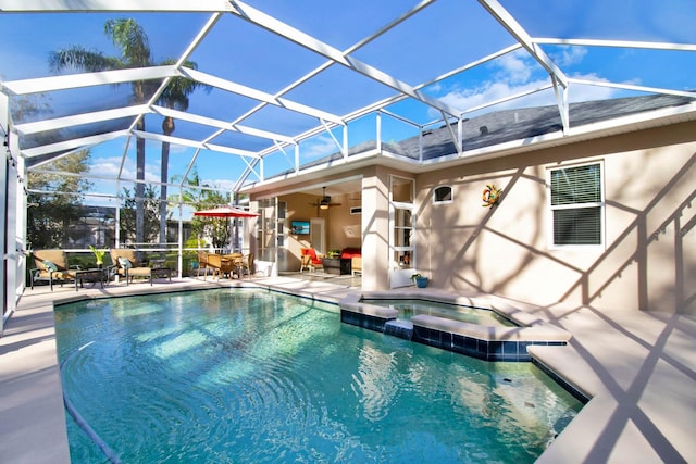 view of swimming pool featuring a lanai, a patio area, ceiling fan, and an in ground hot tub