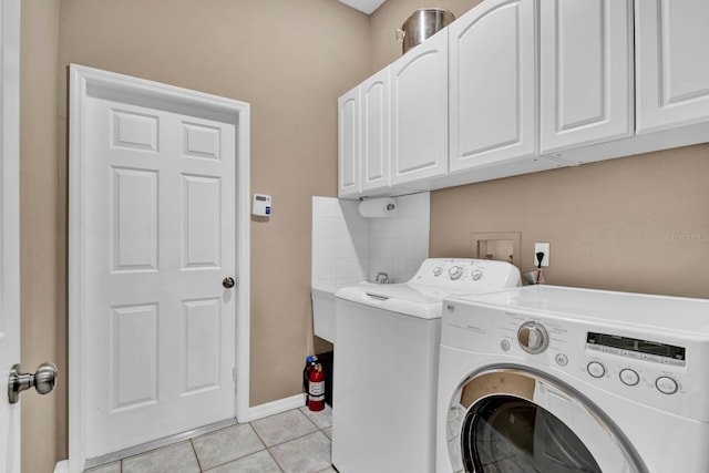 washroom with independent washer and dryer, cabinets, and light tile patterned floors