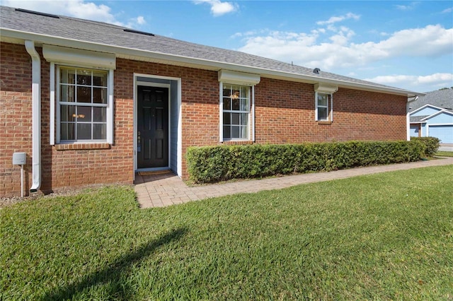 3401 Home Town Ln, Saint Cloud, FL 34769 - view of exterior entry with a yard, brick siding, and roof with shingles