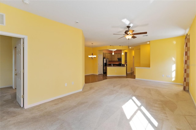 unfurnished living room featuring light carpet and ceiling fan with notable chandelier