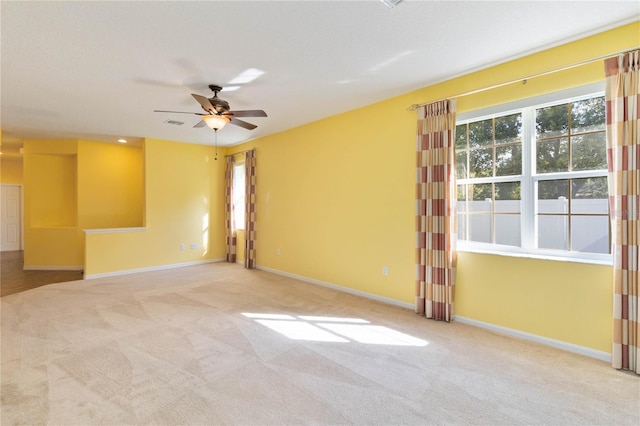 unfurnished room with light colored carpet and ceiling fan