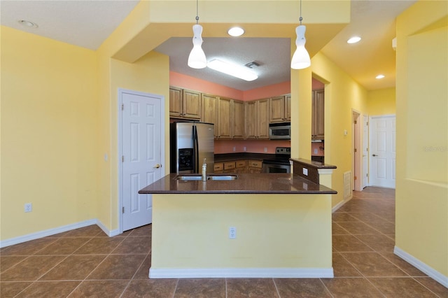 3401 Home Town Ln, Saint Cloud, FL 34769 - kitchen with stainless steel appliances, dark countertops, a sink, a kitchen island with sink, and recessed lighting
