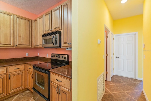 3401 Home Town Ln, Saint Cloud, FL 34769 - kitchen with appliances with stainless steel finishes, dark countertops, tile patterned flooring, and baseboards