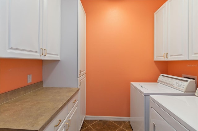 laundry area with dark tile patterned flooring, cabinets, and independent washer and dryer