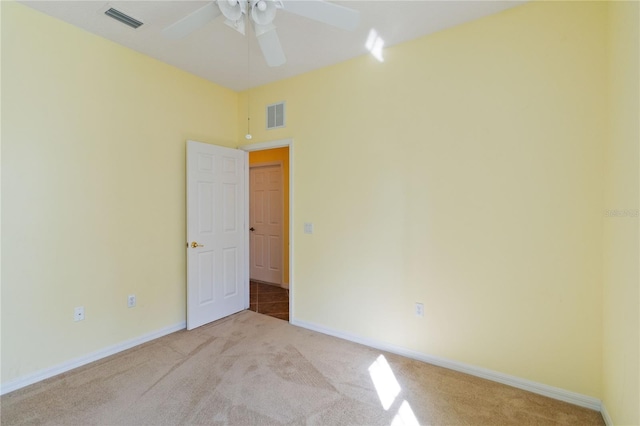 empty room featuring ceiling fan and light carpet