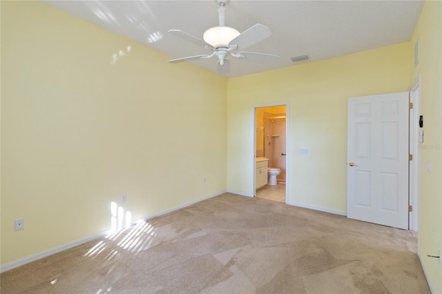 unfurnished bedroom with ensuite bathroom, light colored carpet, and ceiling fan