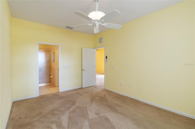 unfurnished bedroom featuring light carpet, ceiling fan, and ensuite bathroom