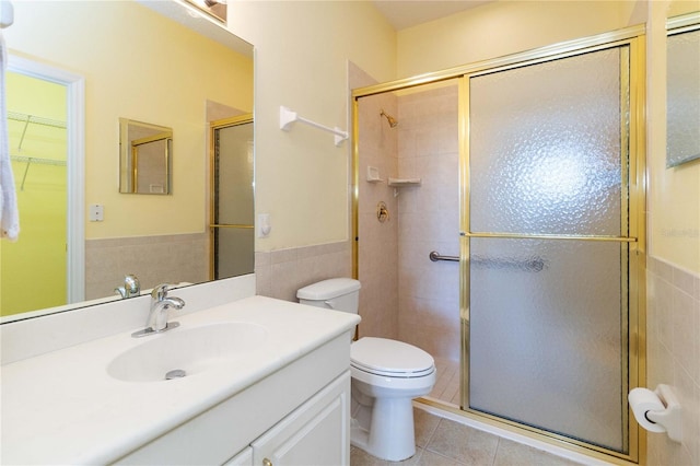 bathroom featuring toilet, tile walls, tile patterned floors, and walk in shower