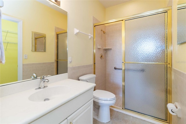 3401 Home Town Ln, Saint Cloud, FL 34769 - full bathroom featuring a shower stall, tile walls, tile patterned flooring, wainscoting, and toilet