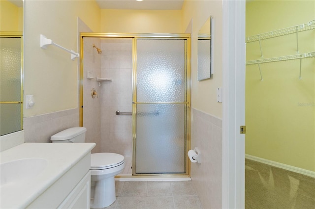 bathroom with vanity, walk in shower, tile patterned flooring, and toilet