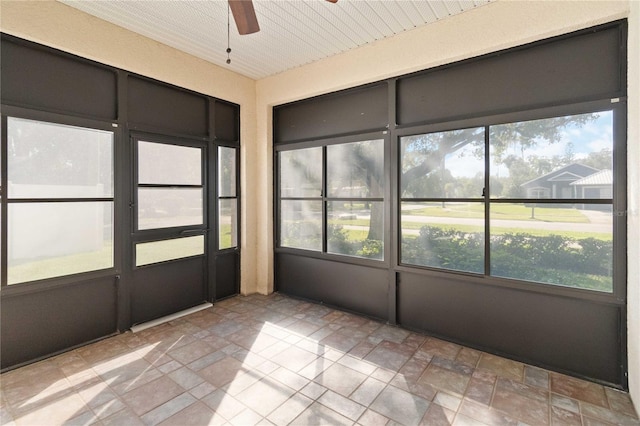 unfurnished sunroom with ceiling fan