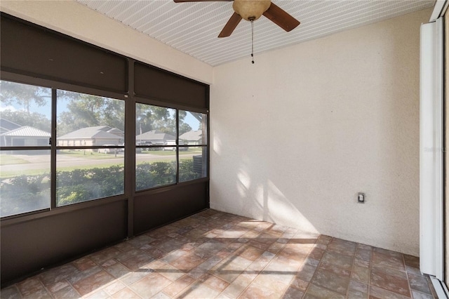 unfurnished sunroom featuring ceiling fan