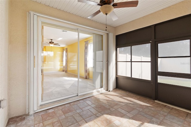 unfurnished sunroom featuring ceiling fan